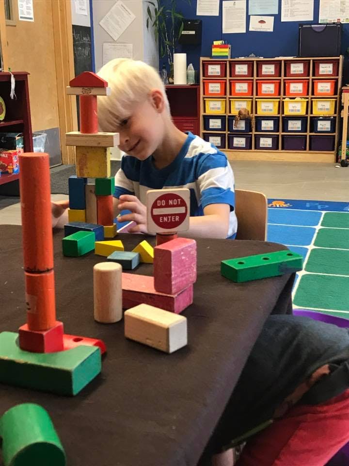 Child playing with building blocks at a table