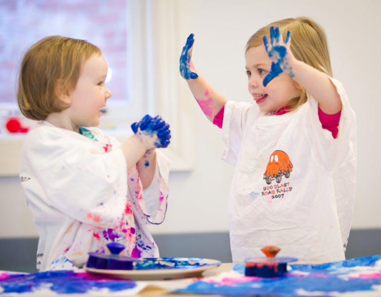 Two children with blue paint on their hands