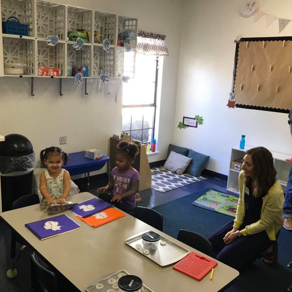 Two children and an adult in a classroom