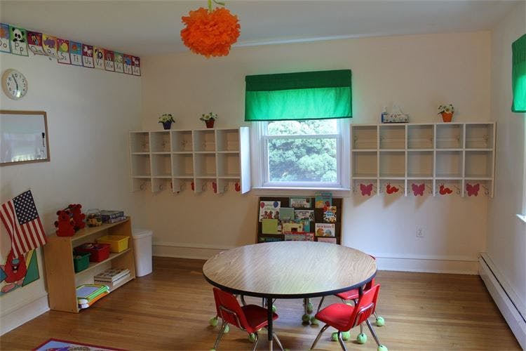 Empty classroom with a round table and small red chairs