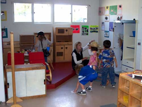 Adult interacting with children in a classroom
