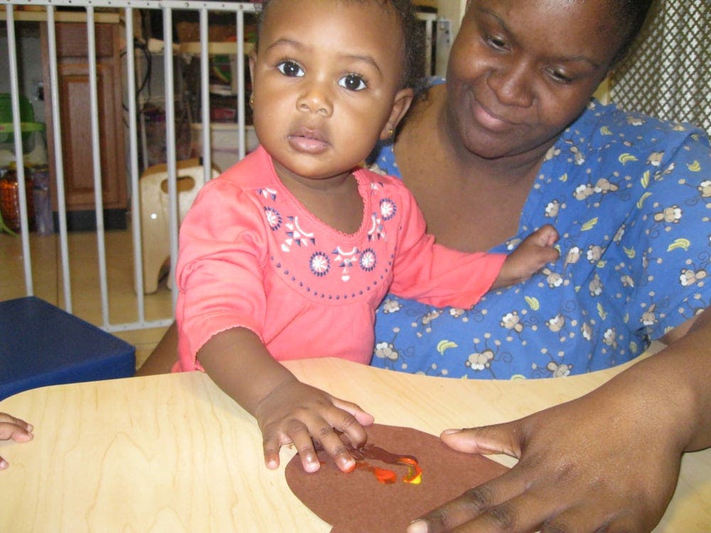 Adult and child at a table with a craft