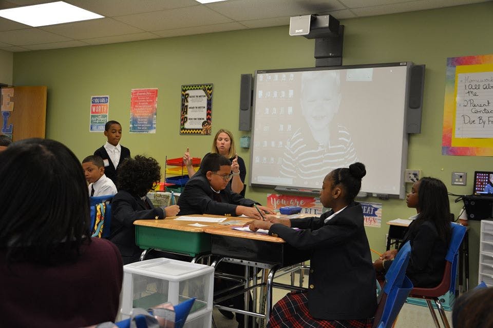 Adult and children in a classroom with a whiteboard