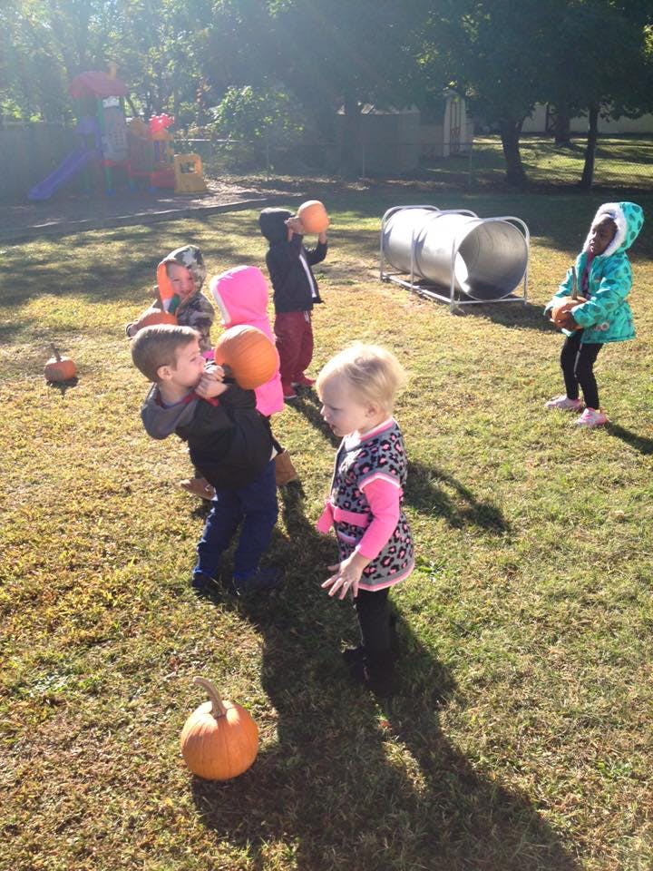 Children playing with pumpkins outdoors
