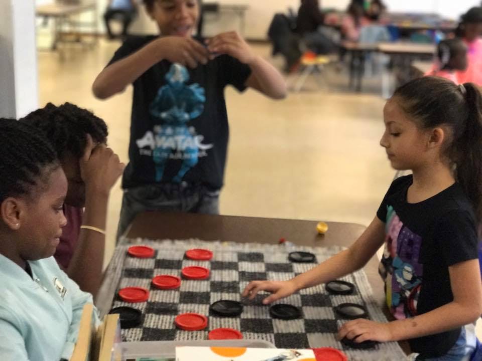 Three children playing checkers