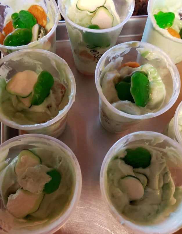 Multiple cups of dip with sliced vegetables