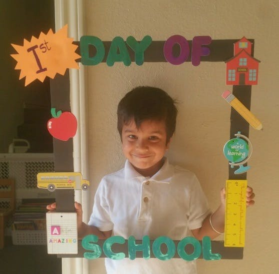 Child holding a "1st Day of School" frame