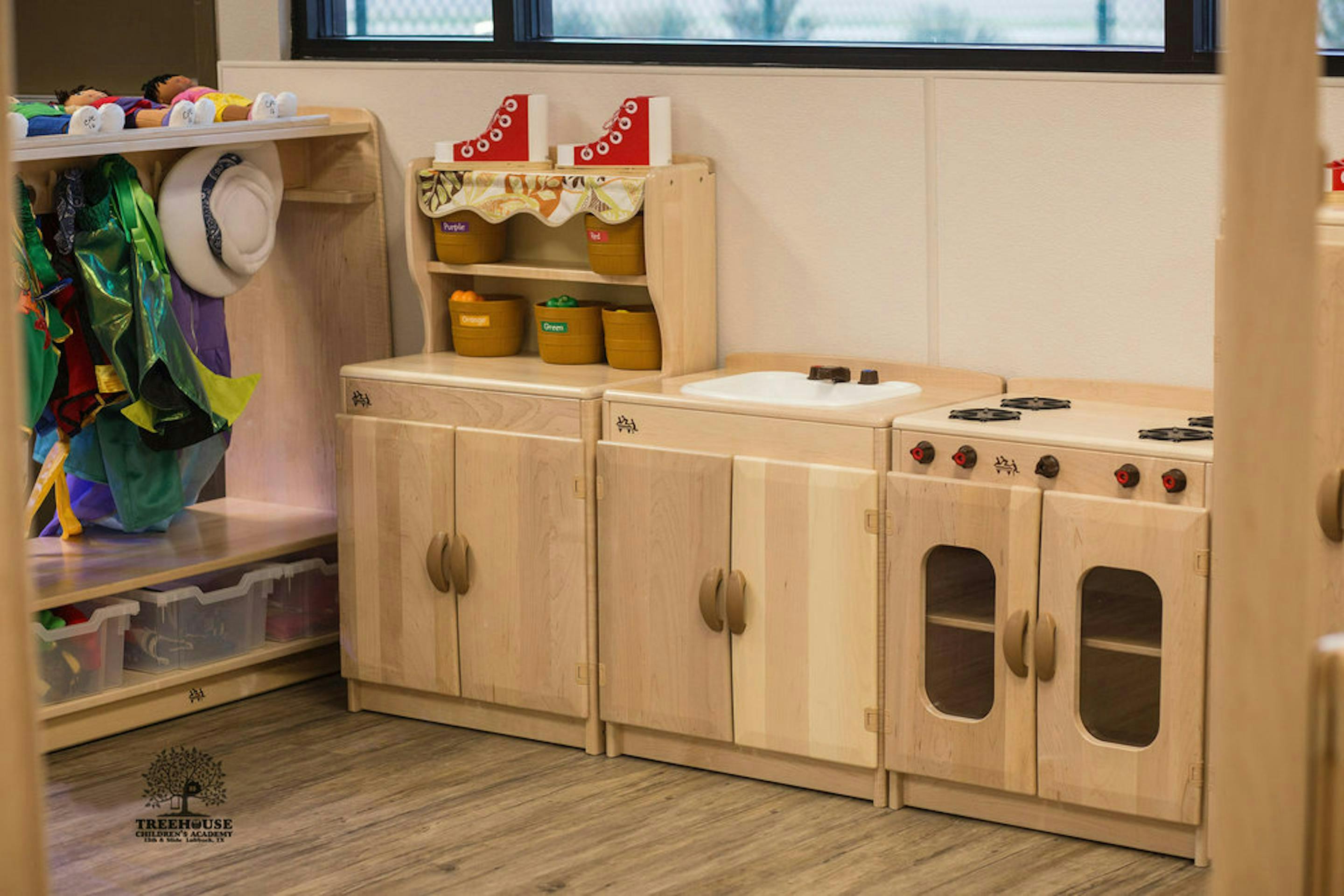 Wooden play kitchen with sink and stove in a classroom