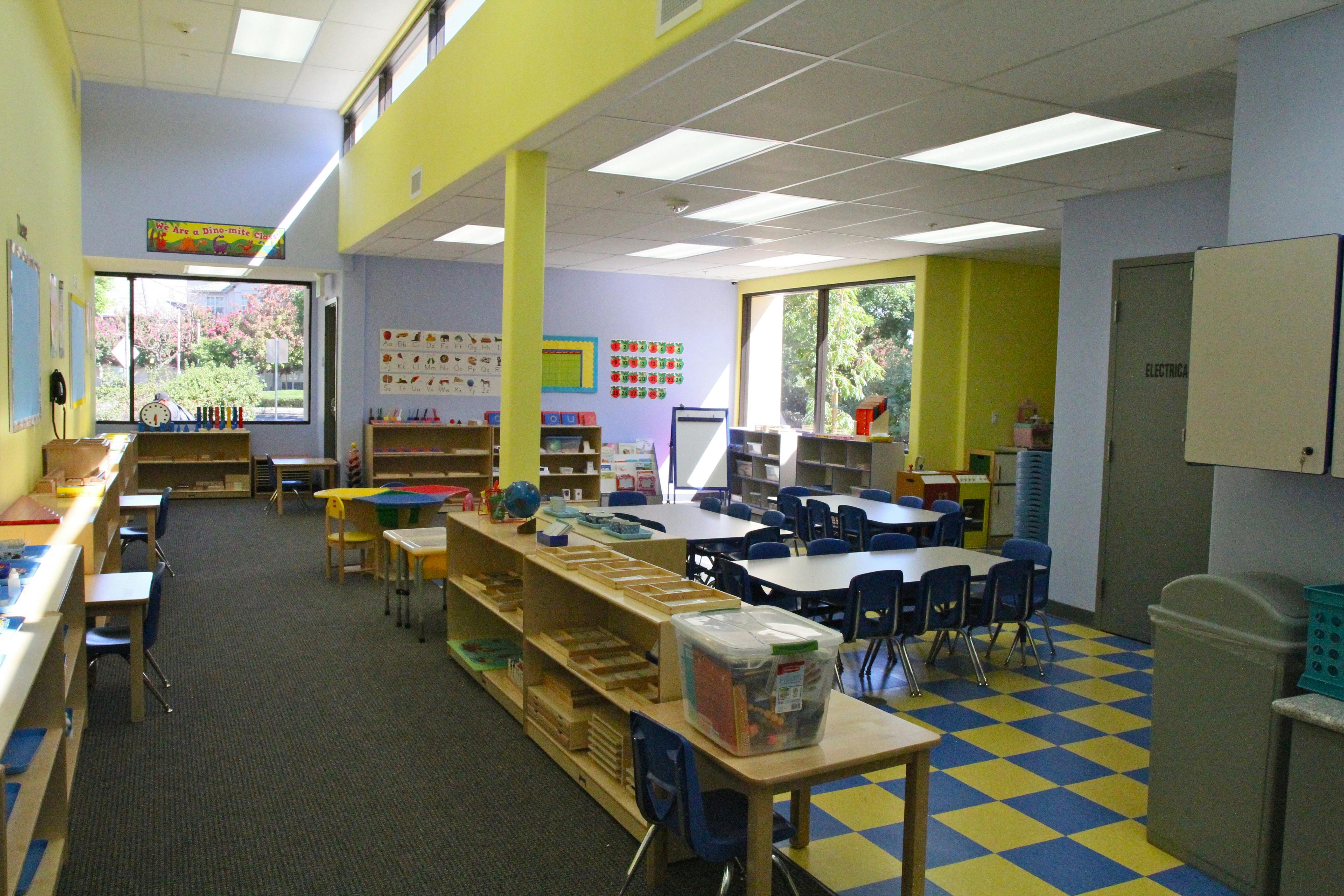 Empty classroom with tables, chairs, and shelves