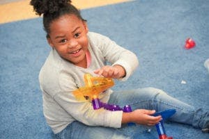 Child playing with a toy on the floor