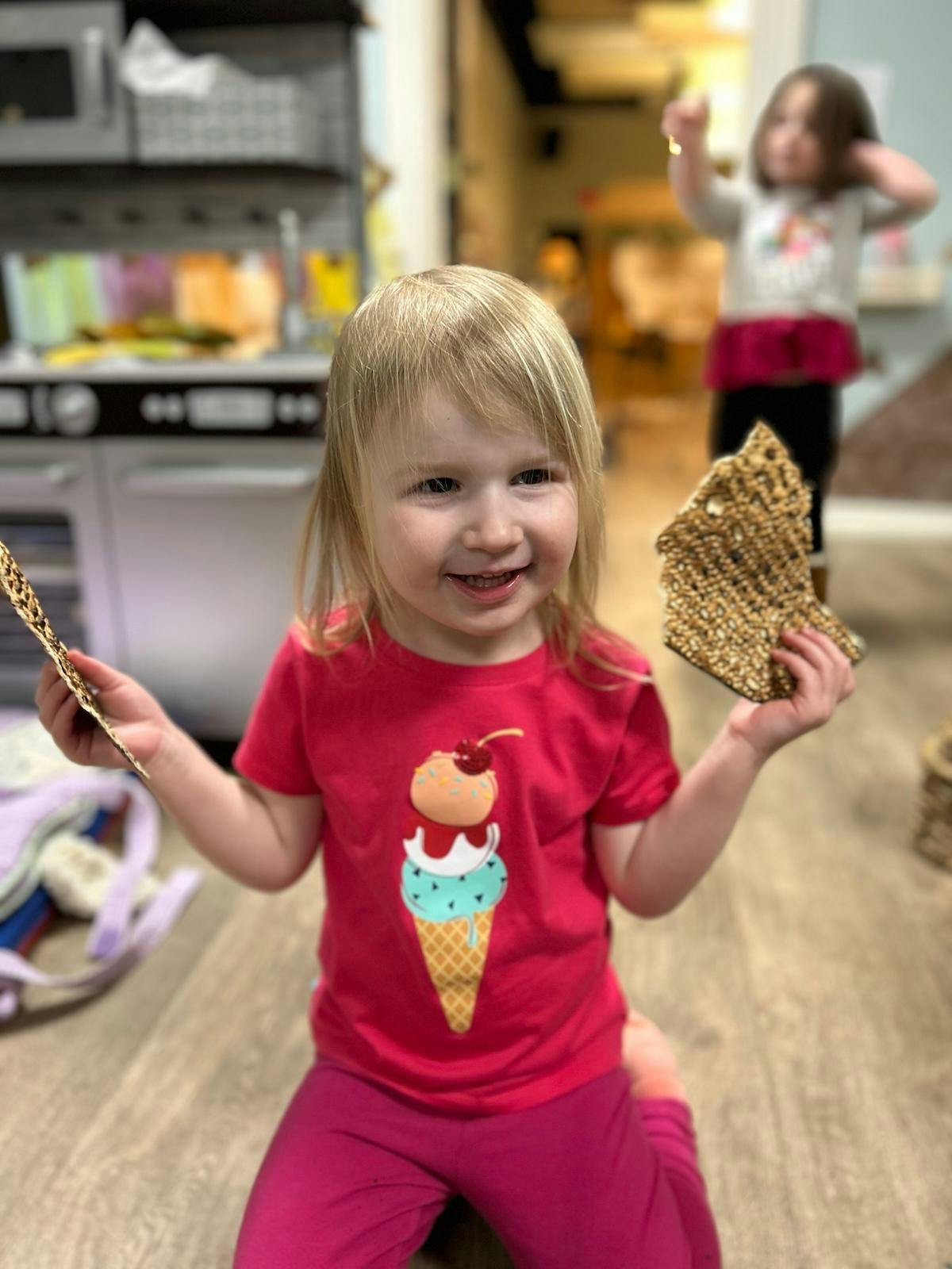 Child holding two pieces of flatbread