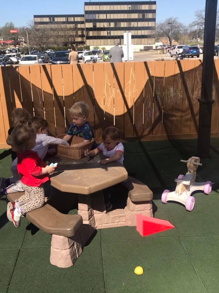 Children playing at a small picnic table on a playground