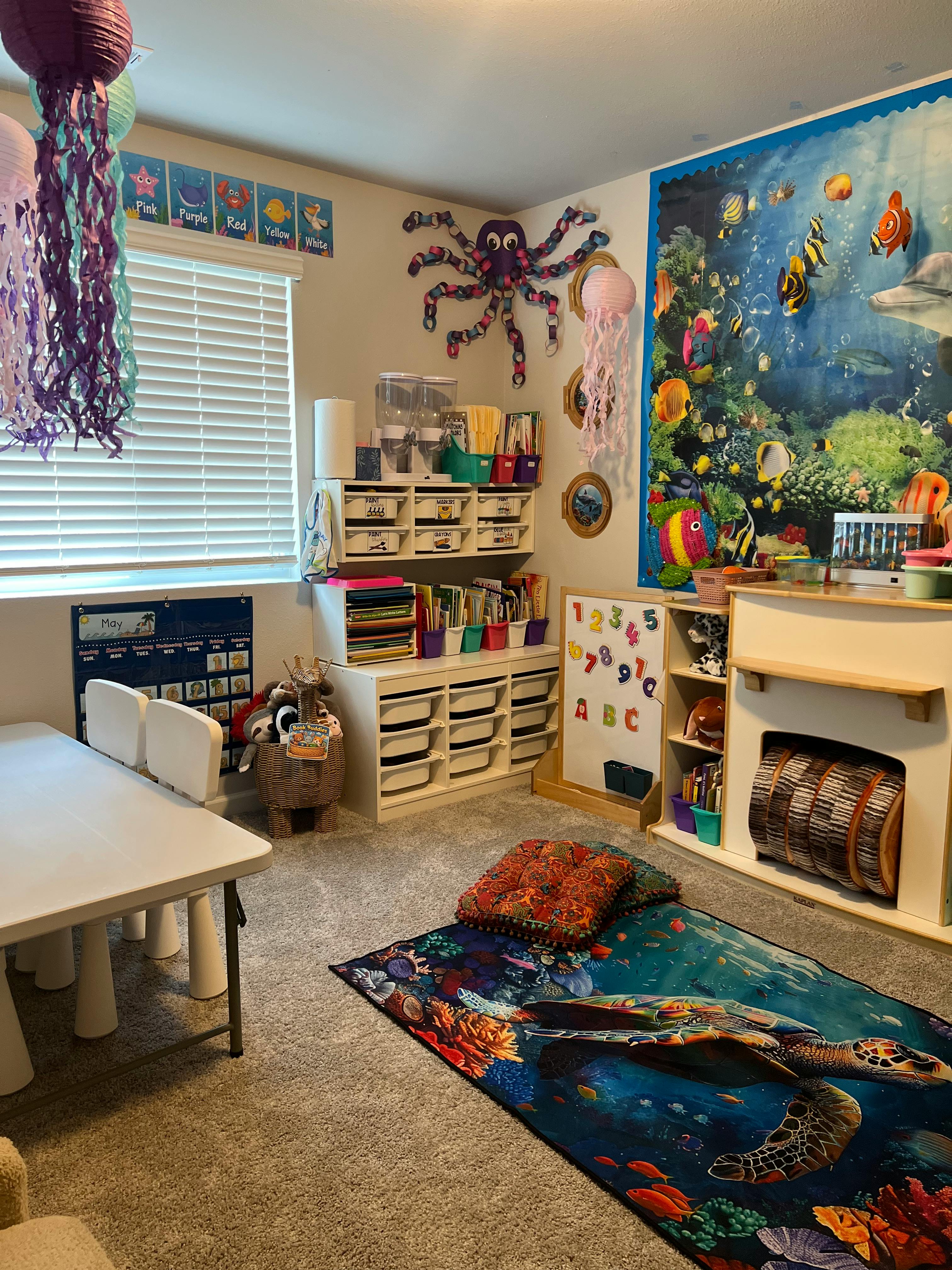 Ocean-themed classroom with a table and chairs, storage units, and a calendar