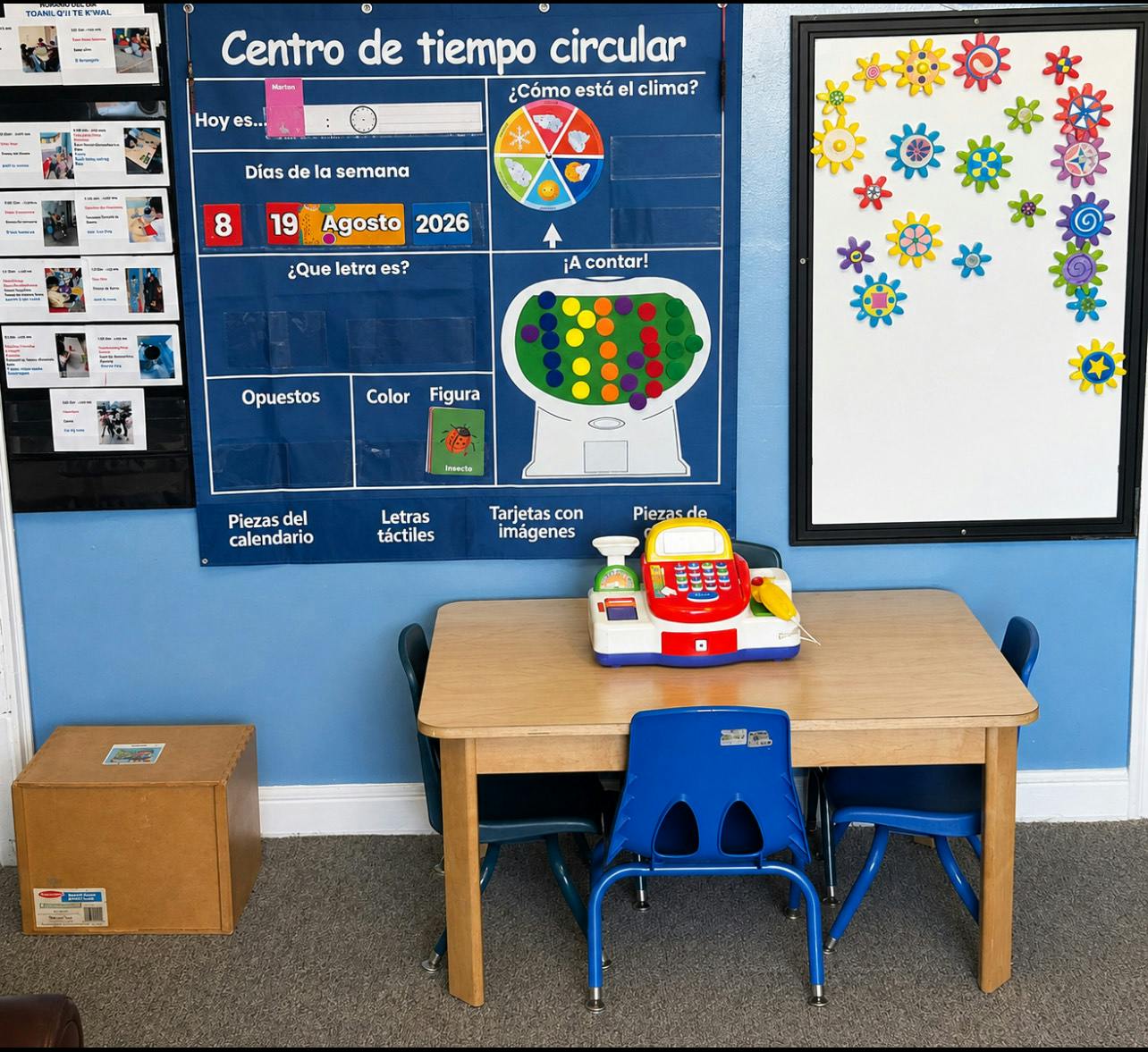 Classroom wall with calendar chart and toy cash register on a small wooden table