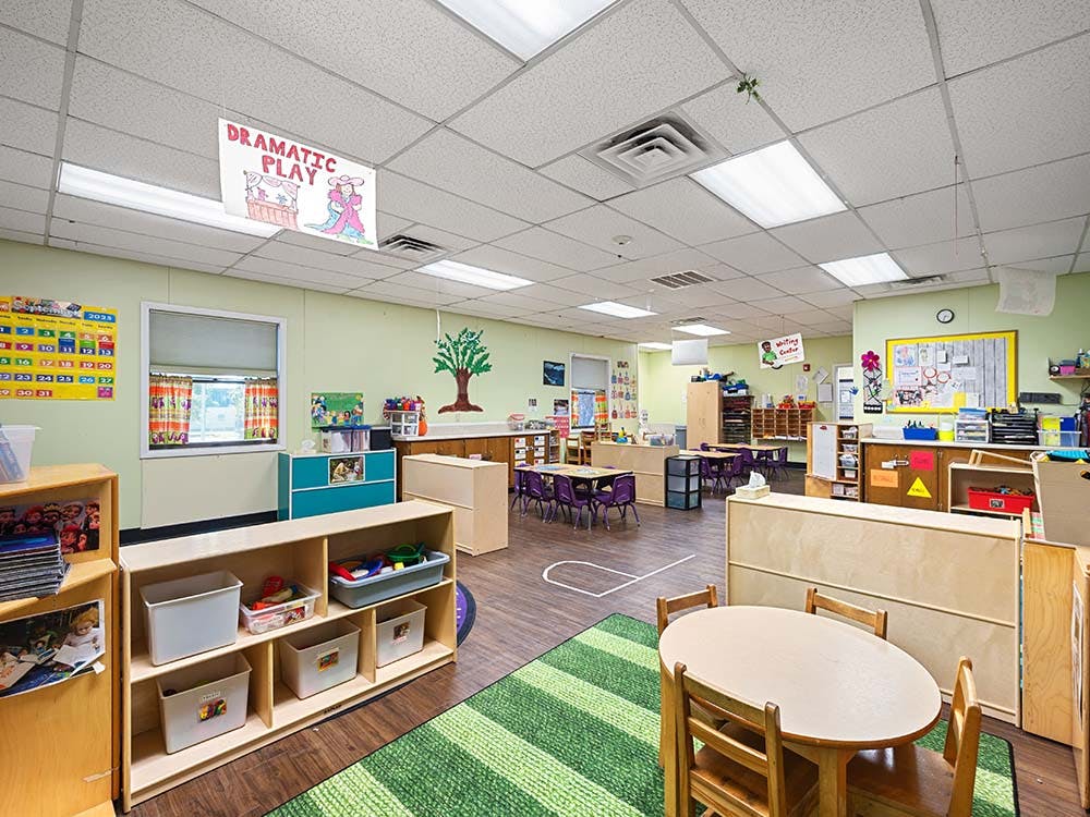Empty colorful children's classroom with small tables and chairs