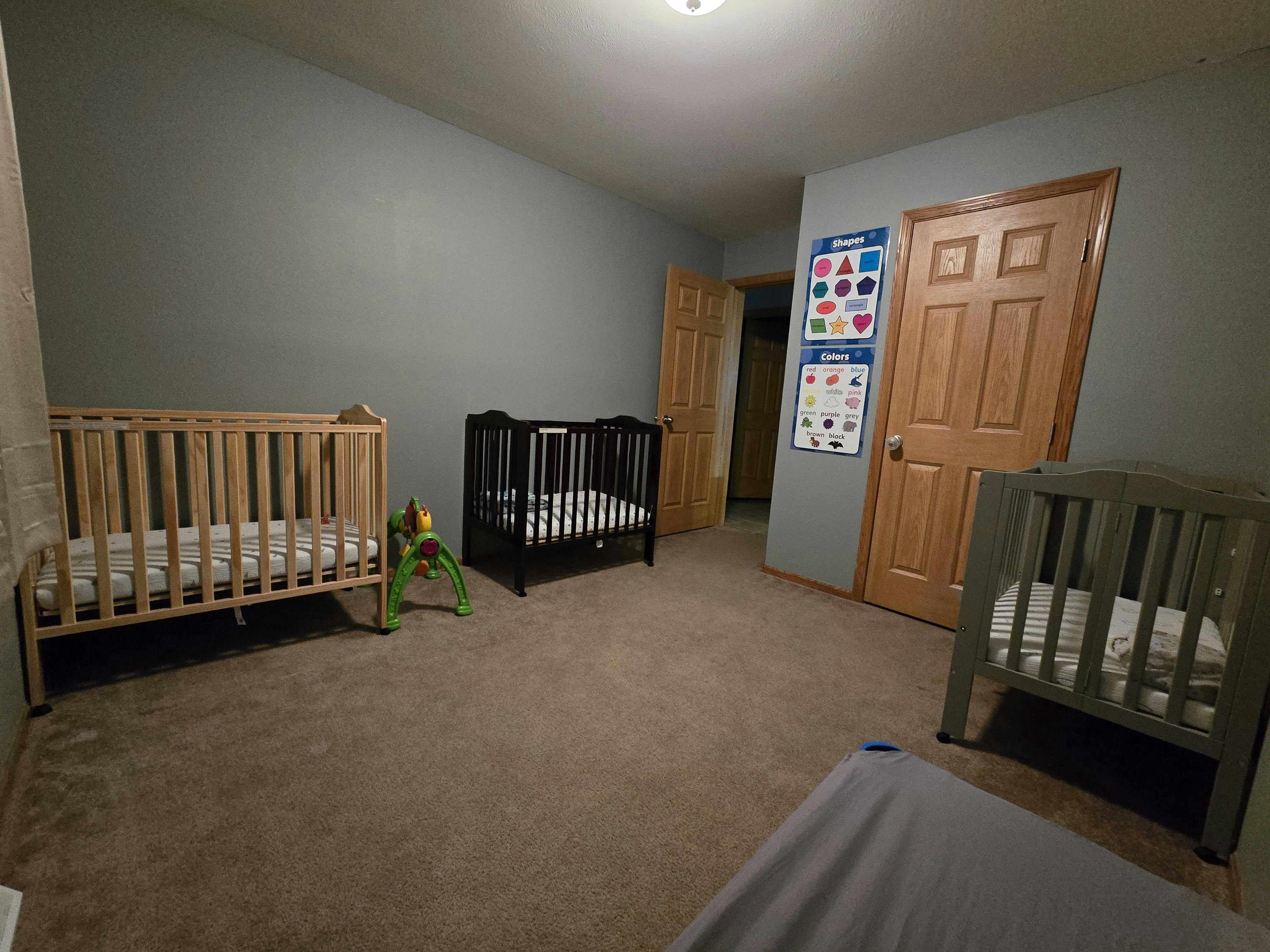 Three empty cribs in a room