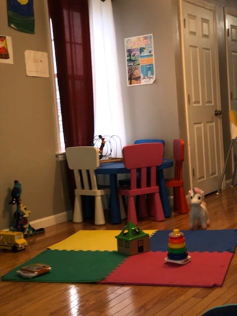 Children's play area with small table and chairs, toys on a colorful mat