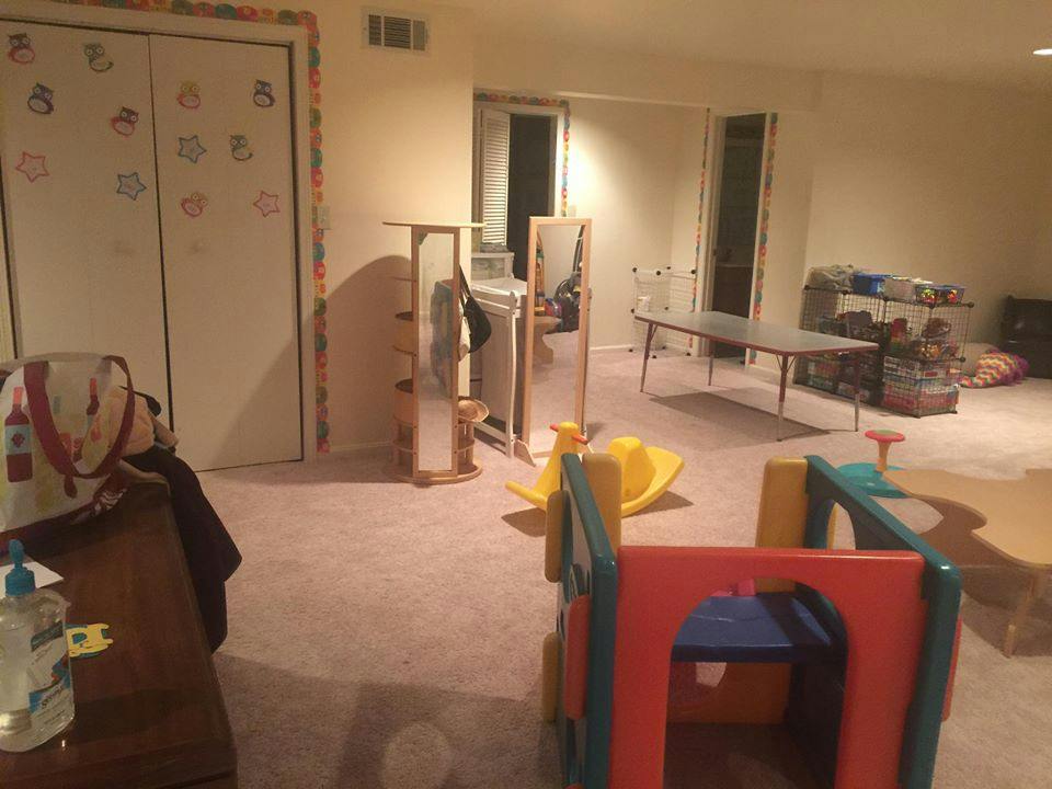 Playroom with colorful play structure, mirrors, and a table