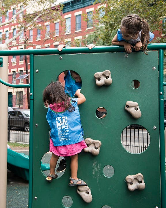 Two children on a climbing wall at a playground