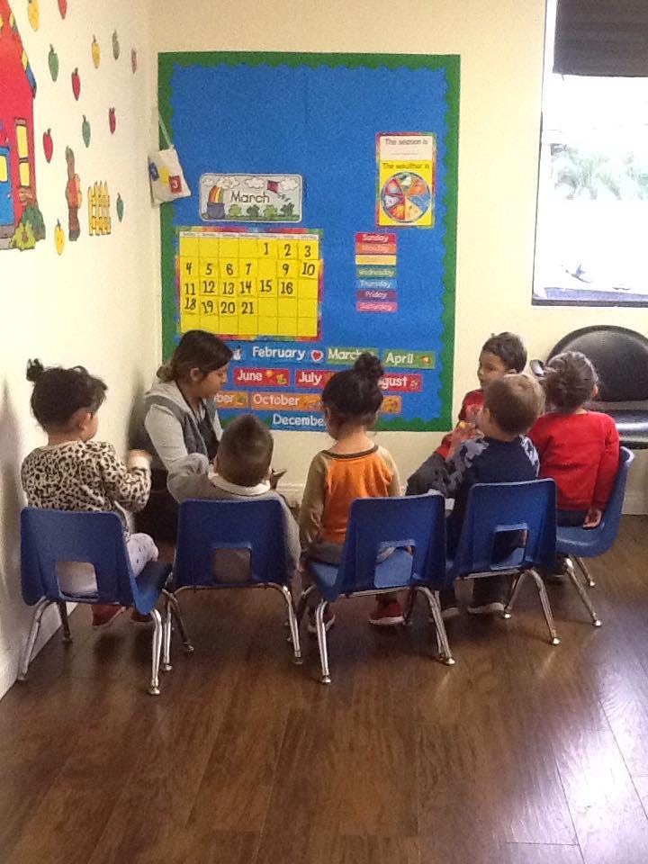 Adult and children sitting in chairs in a classroom