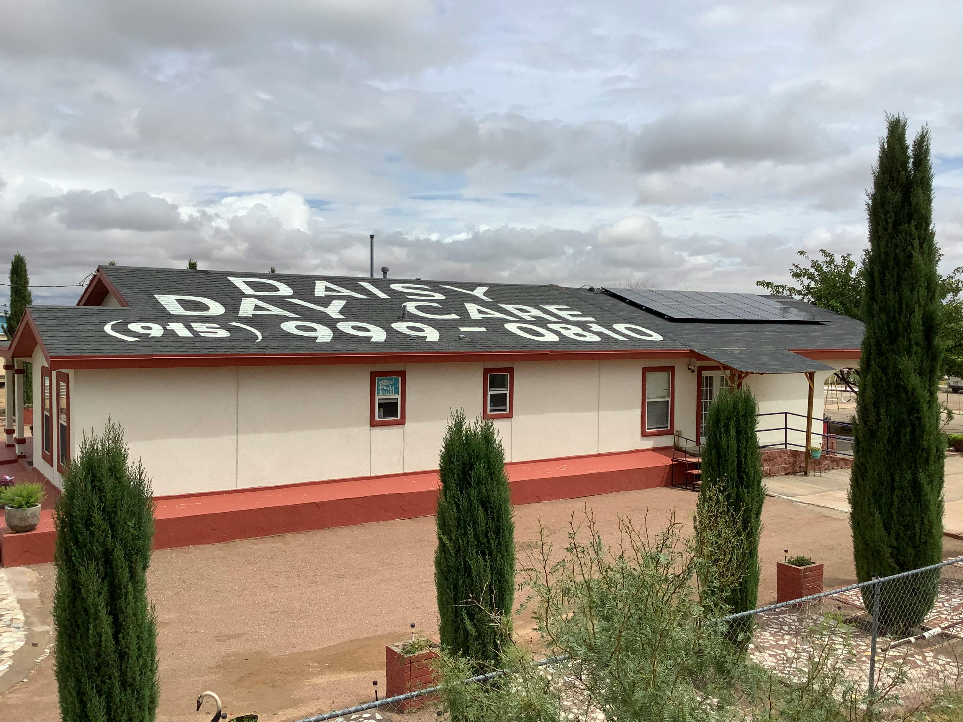 Building with "Daisy Day Care (915) 999-0810" on the roof