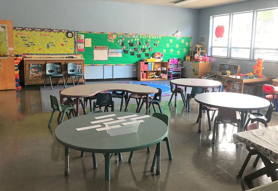 Empty classroom with small tables and chairs