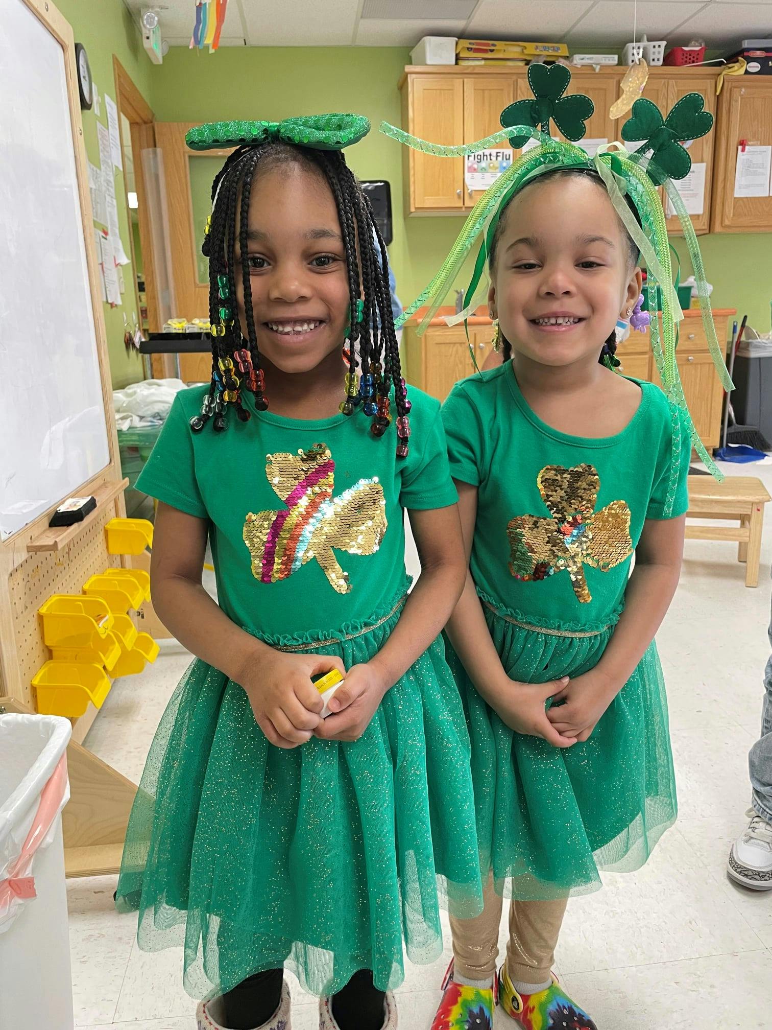 Two children in green dresses with shamrocks
