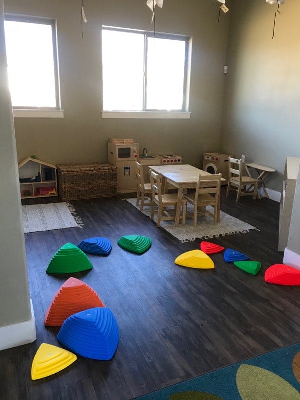 Playroom with colorful stepping stones on the floor and small tables and chairs