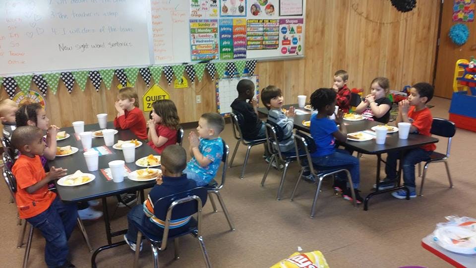 Children sitting at tables in a classroom