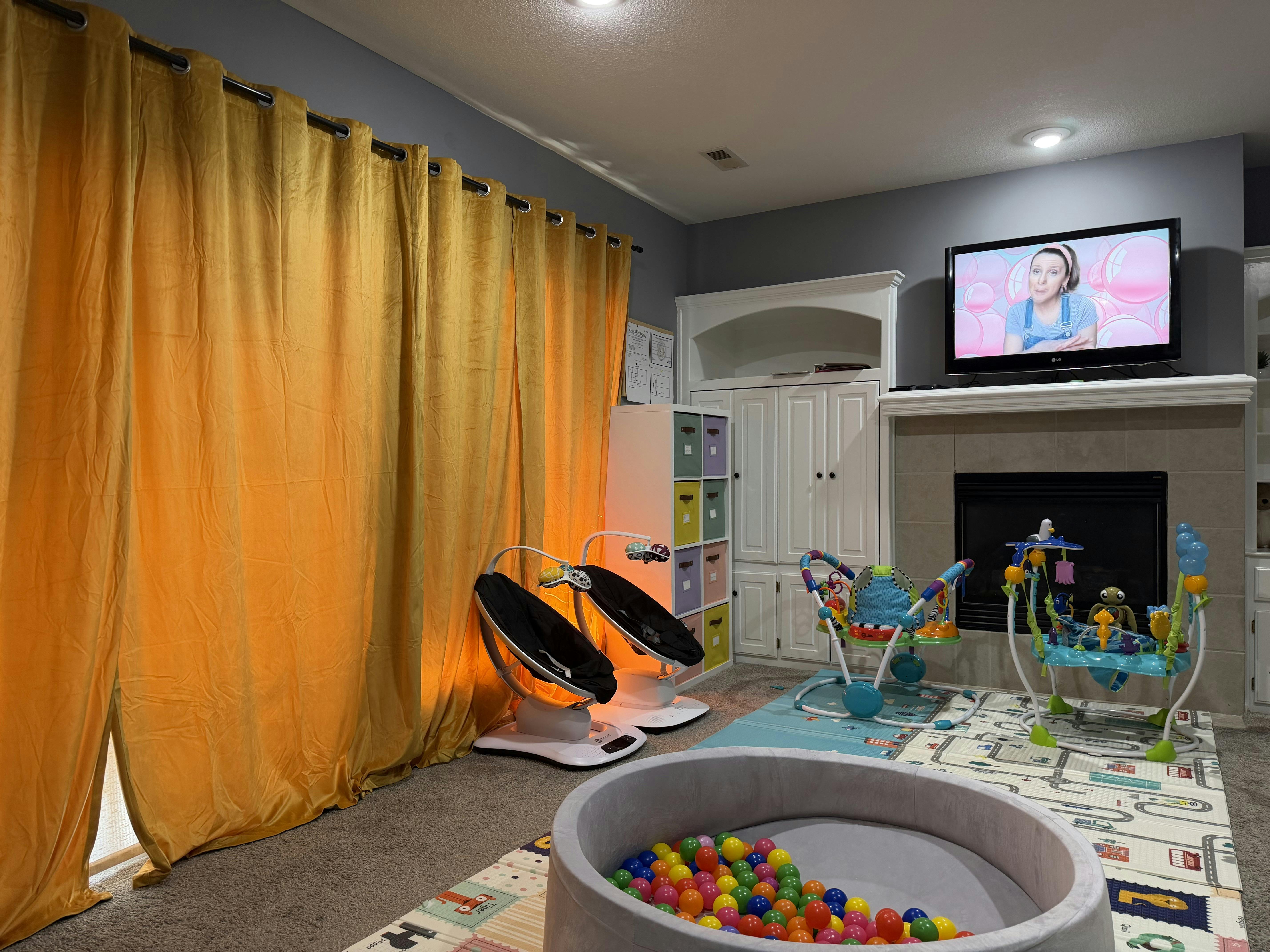 Baby swings, bouncer, and ball pit in a playroom