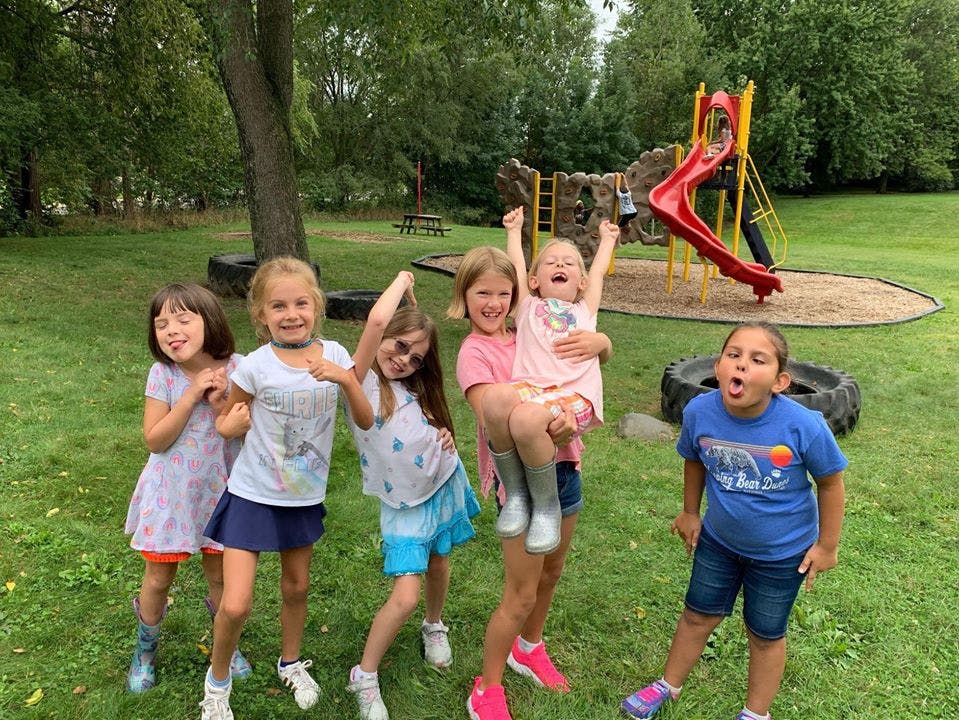 Group of children playing outdoors near a playground slide