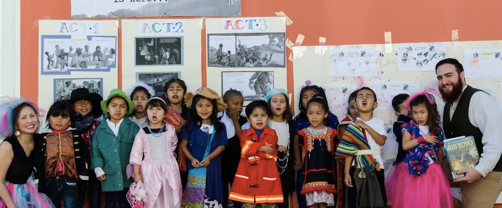 Group of children and two adults posing for a photo