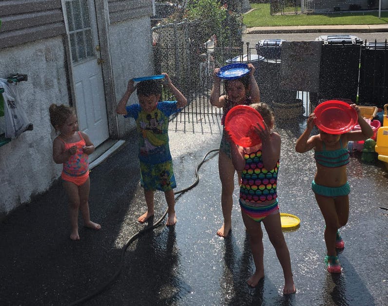 Children playing with water and plastic plates