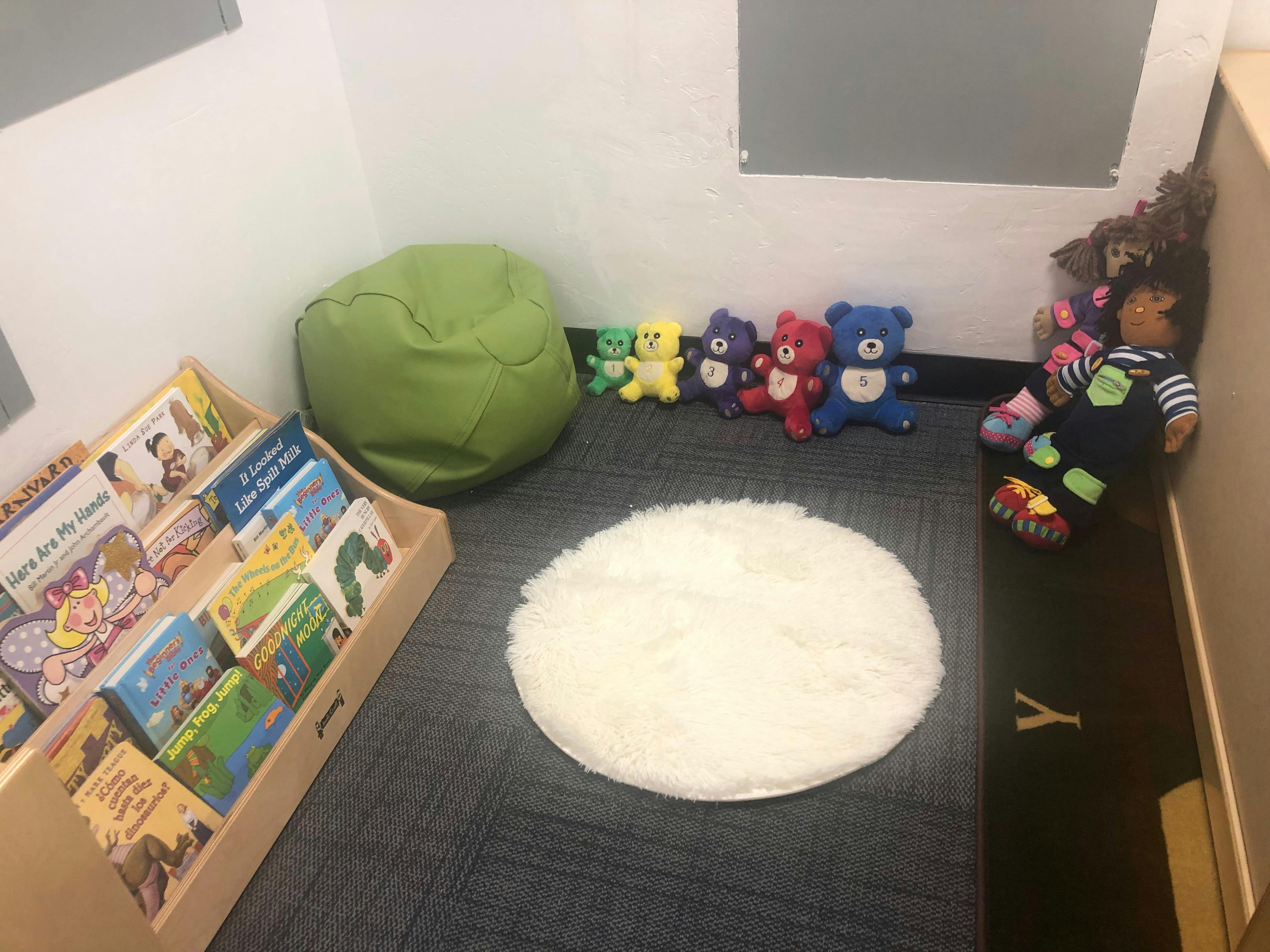 Children's reading nook with books, beanbag, and stuffed animals