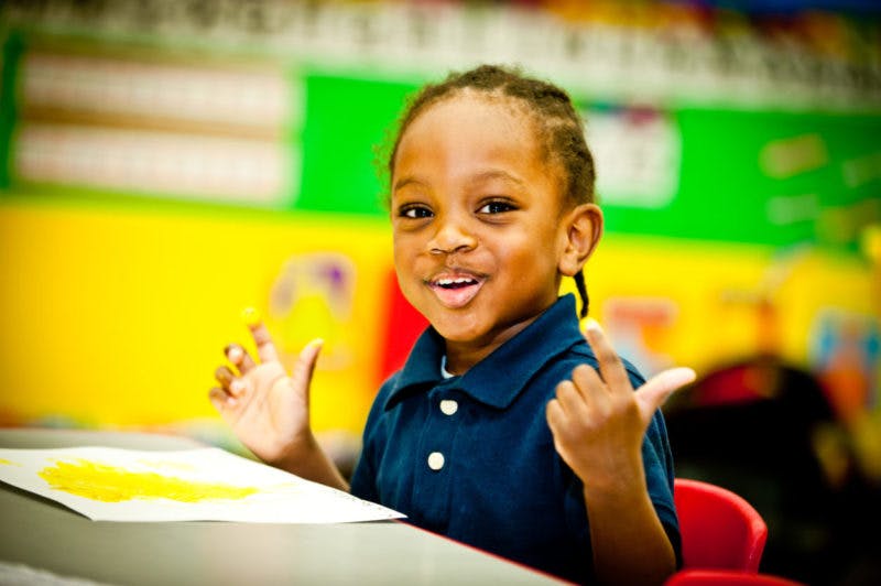 Child finger painting in a classroom