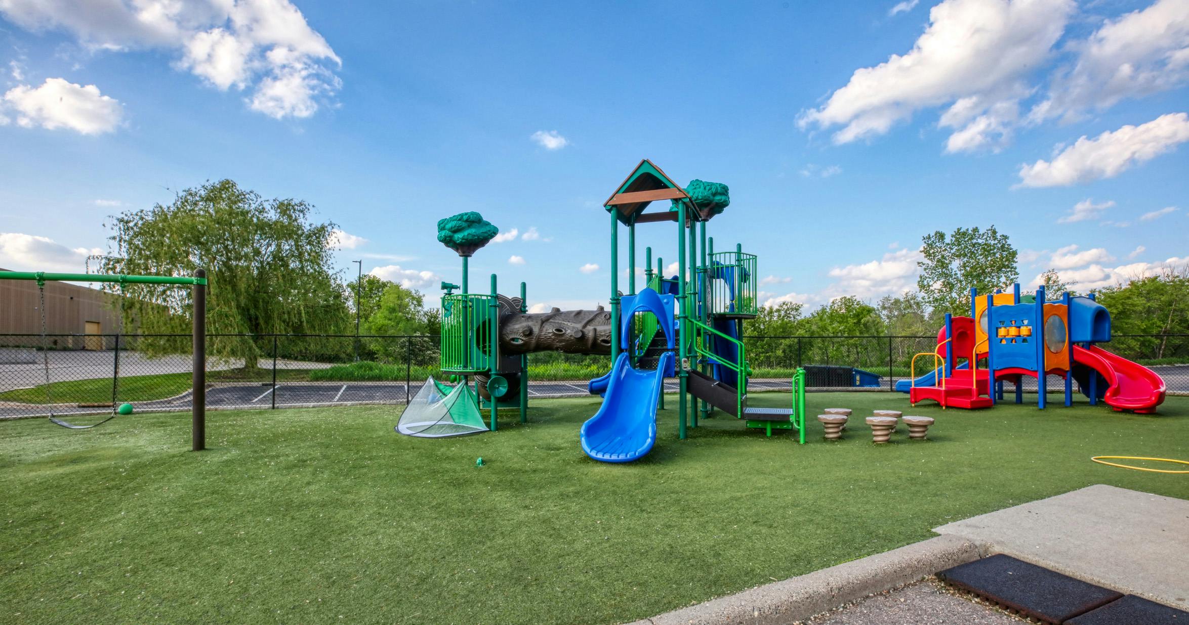 A colorful playground with multiple slides, climbing structures, and swings