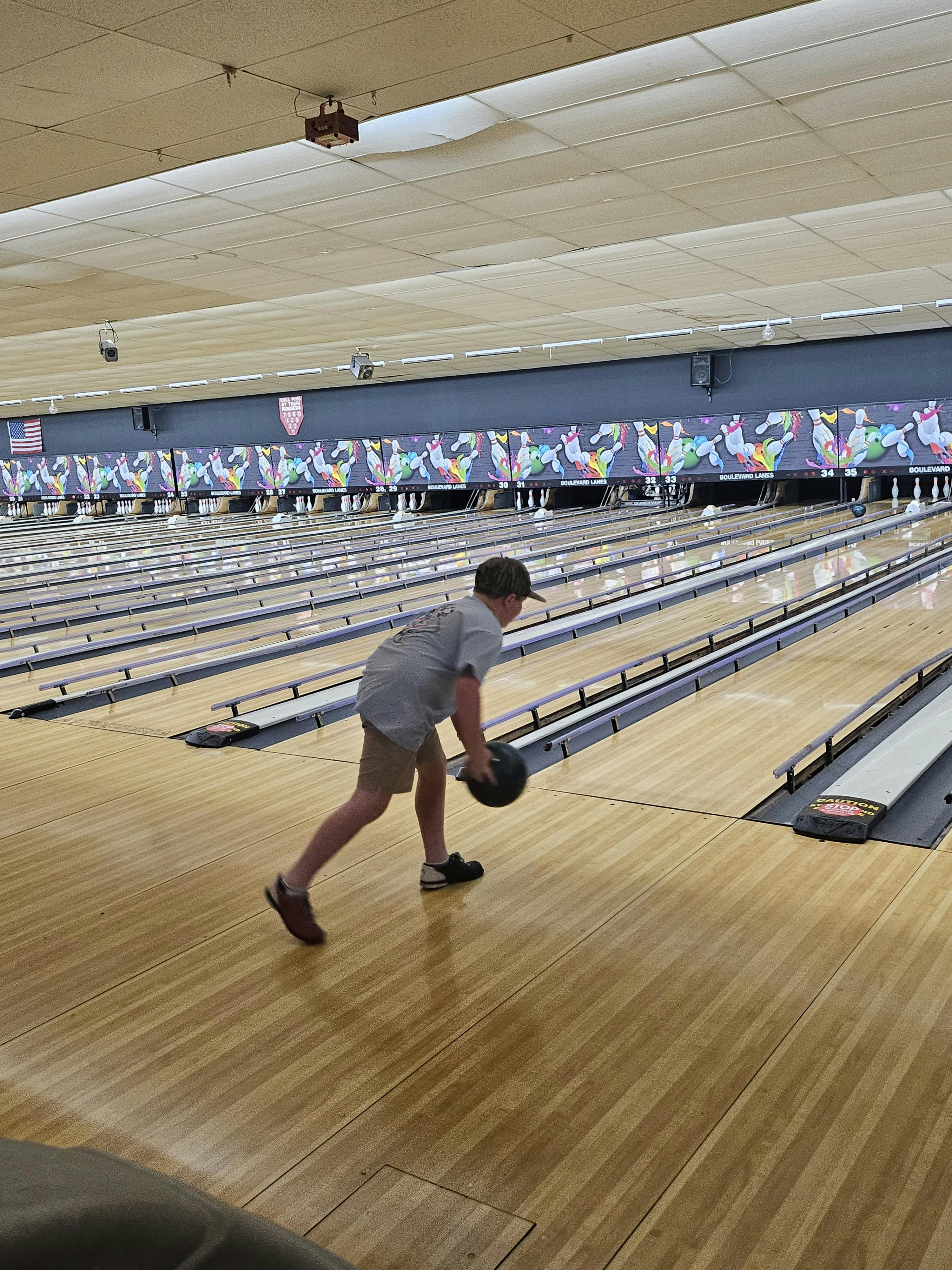 Person holding a bowling ball on a bowling lane