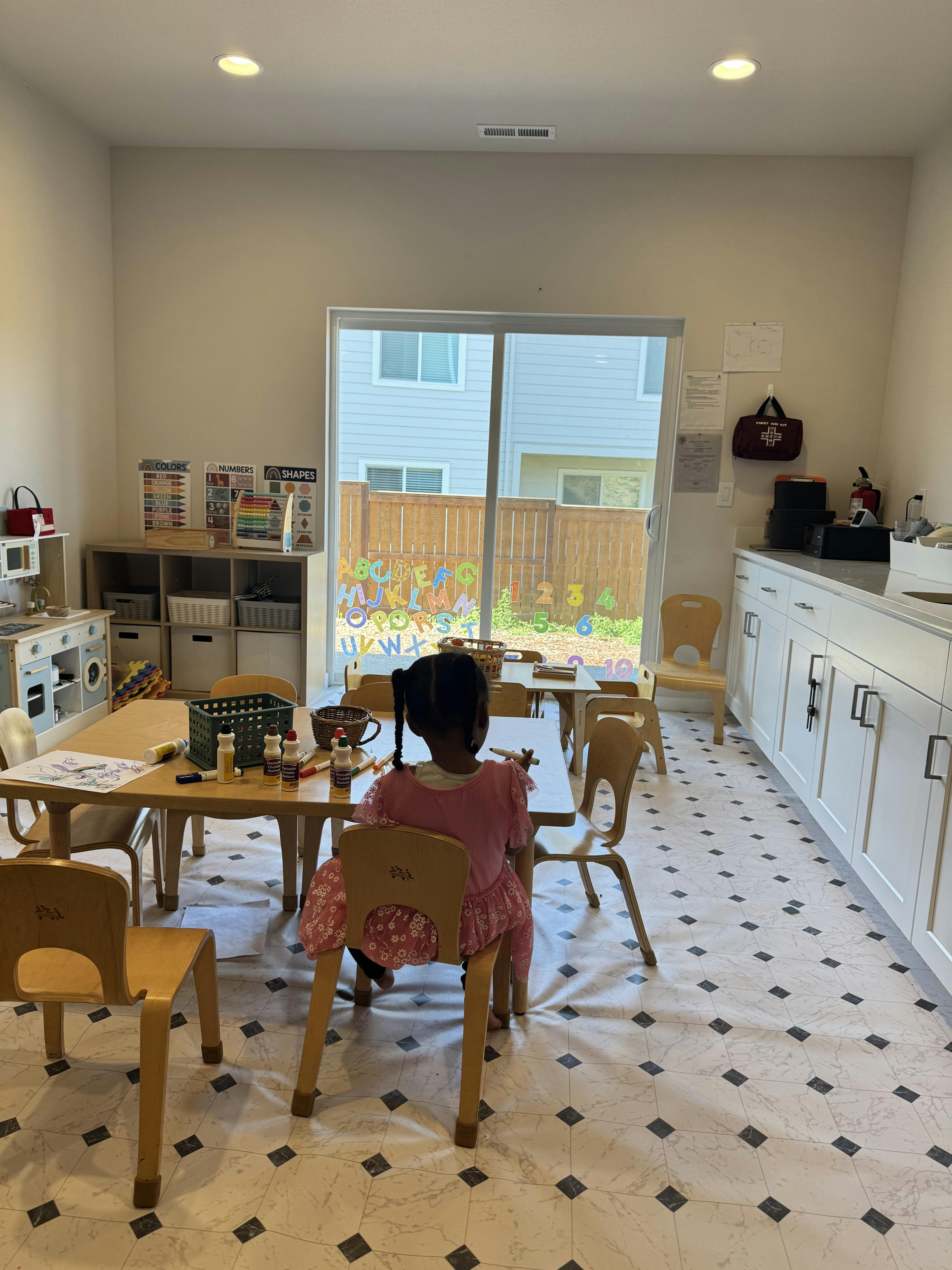 Child sitting at a table coloring in a classroom