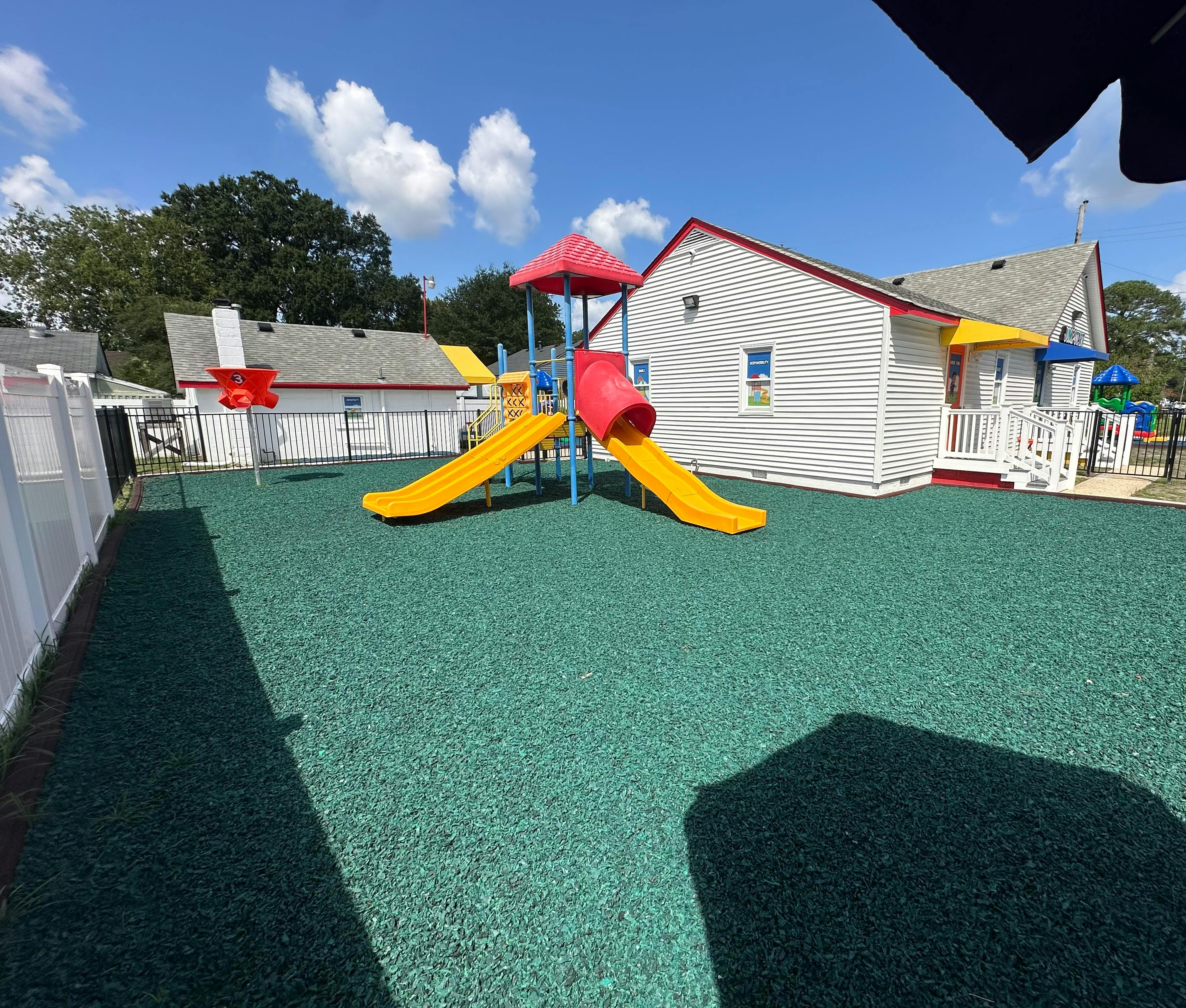 Playground with yellow slides and green ground covering