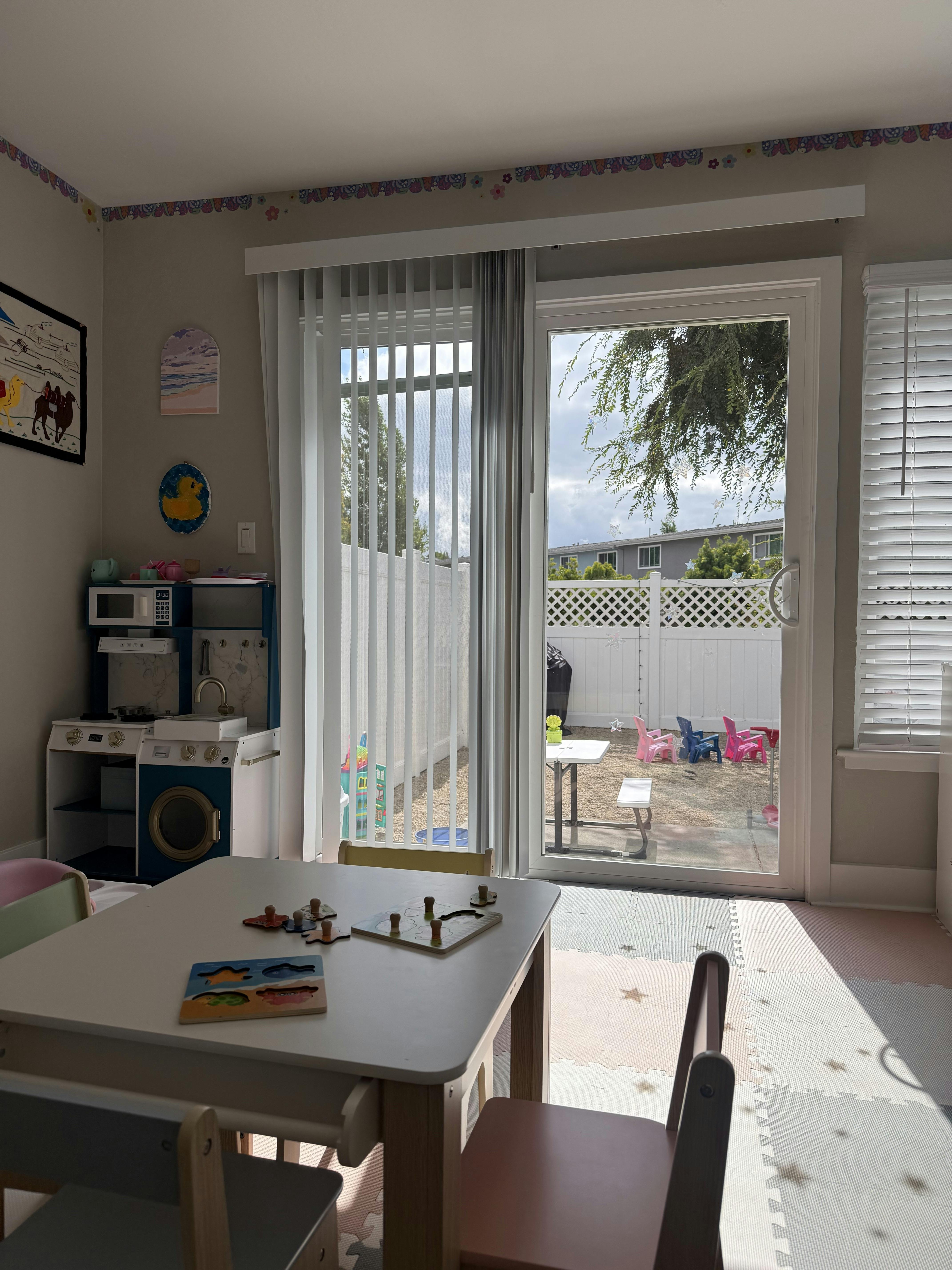 Childs table with puzzles in a playroom looking out to a backyard