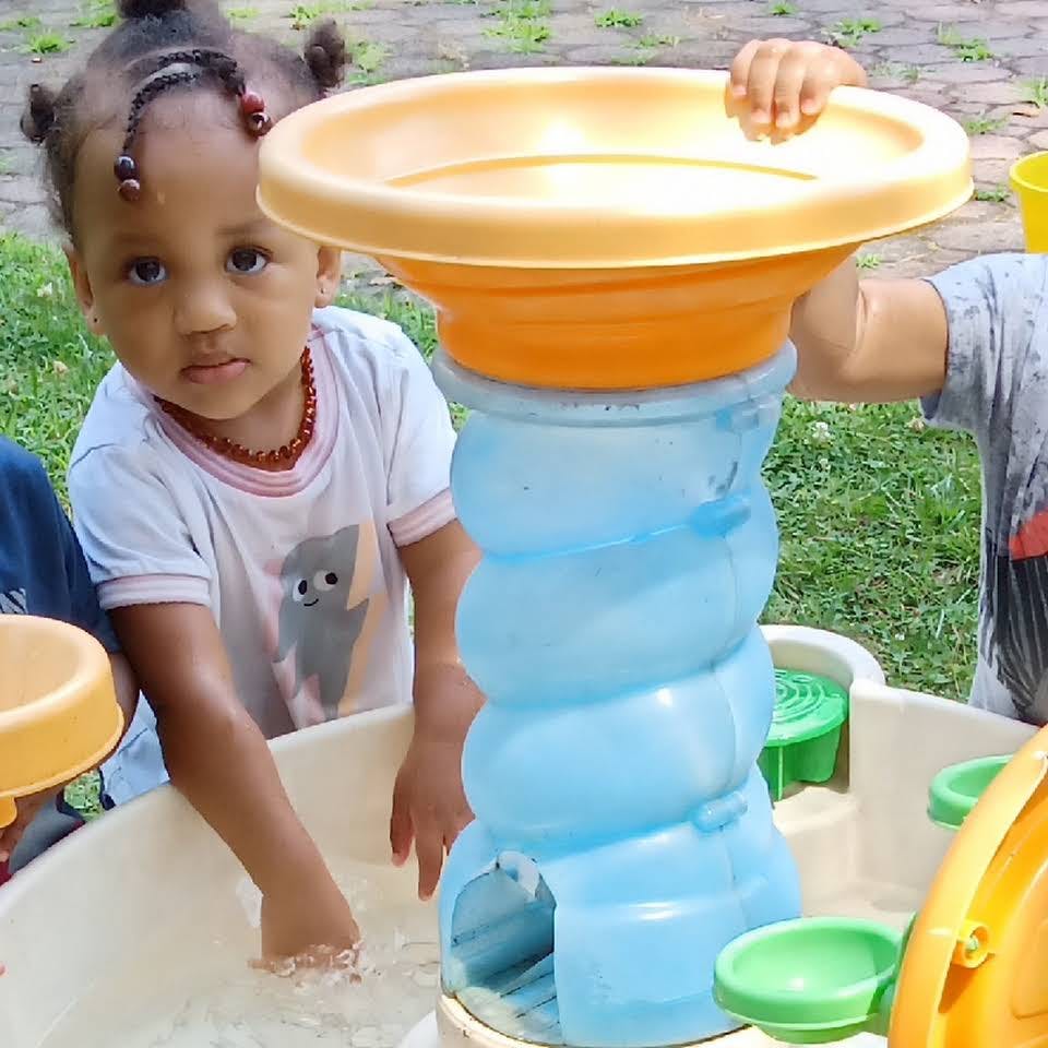 Child playing with water table and toy