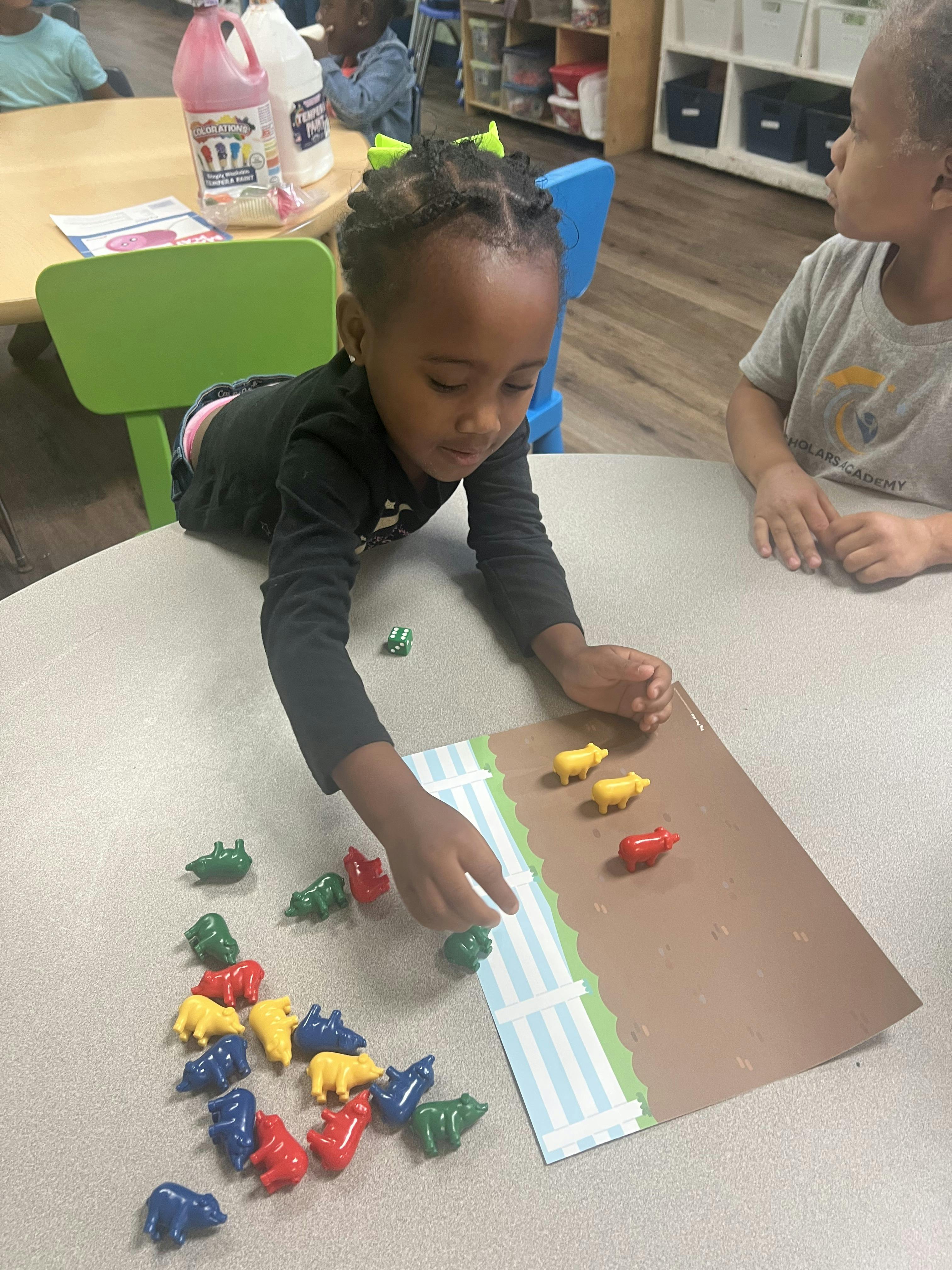 Child playing with animal-shaped counters on a table