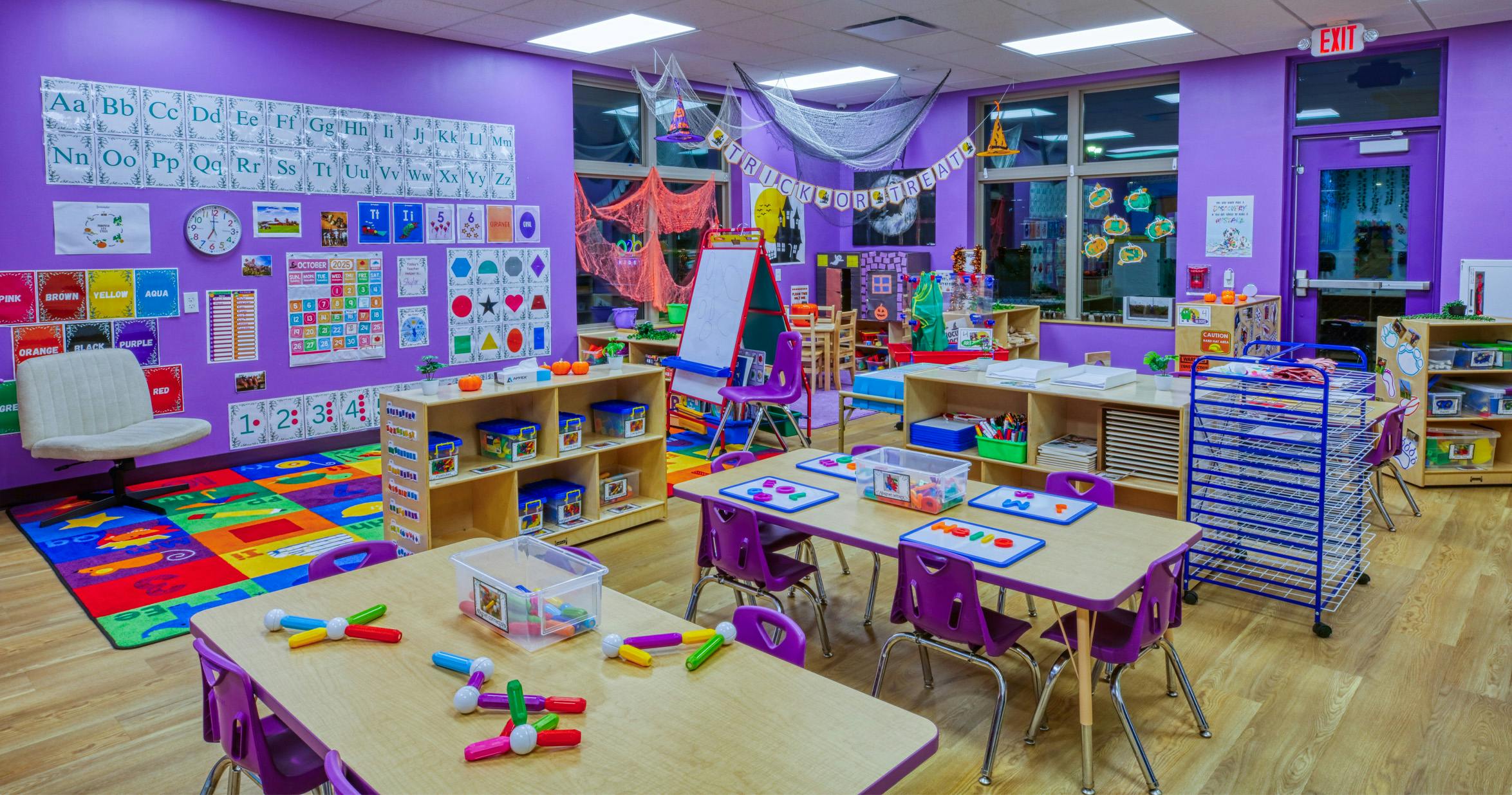 Classroom decorated for Halloween with tables, chairs, and learning materials