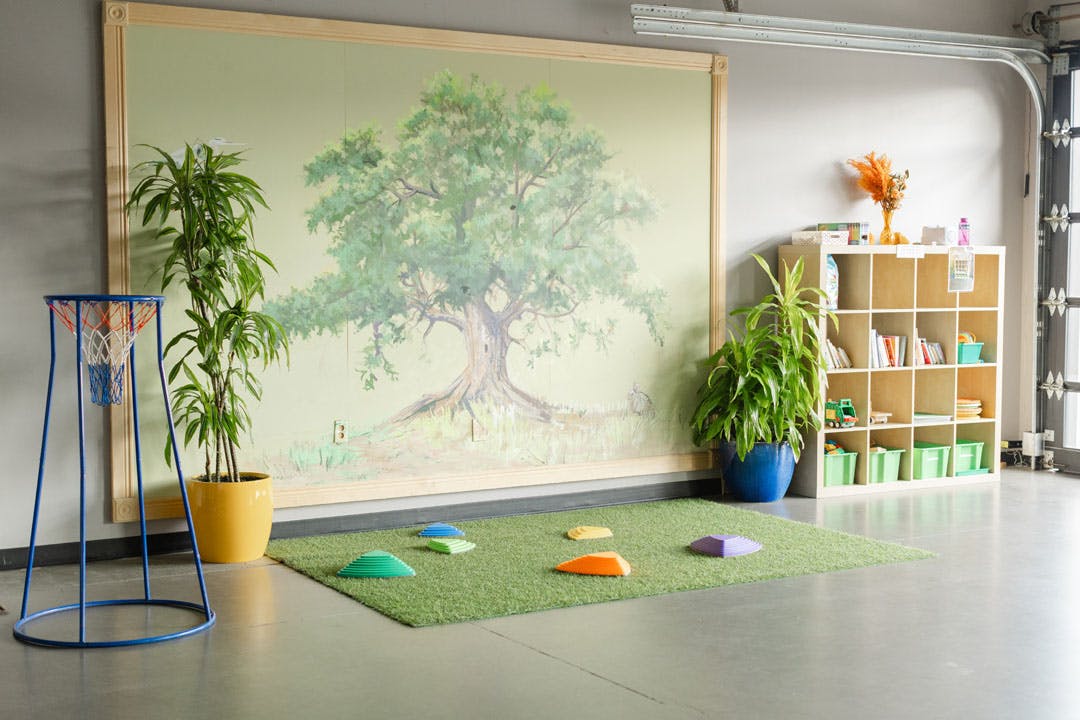Indoor play area with artificial turf mat and balance stepping stones