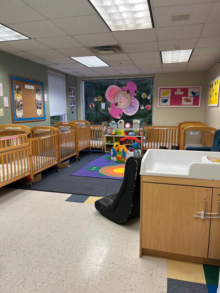 Cribs in a daycare classroom with a changing table and play mat