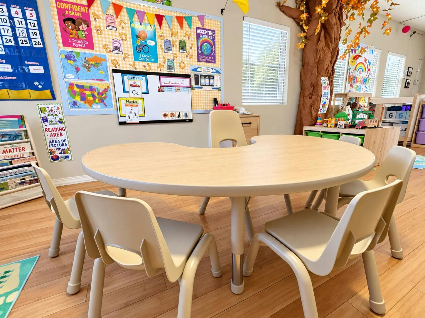 Kidney shaped table with small chairs in a decorated classroom