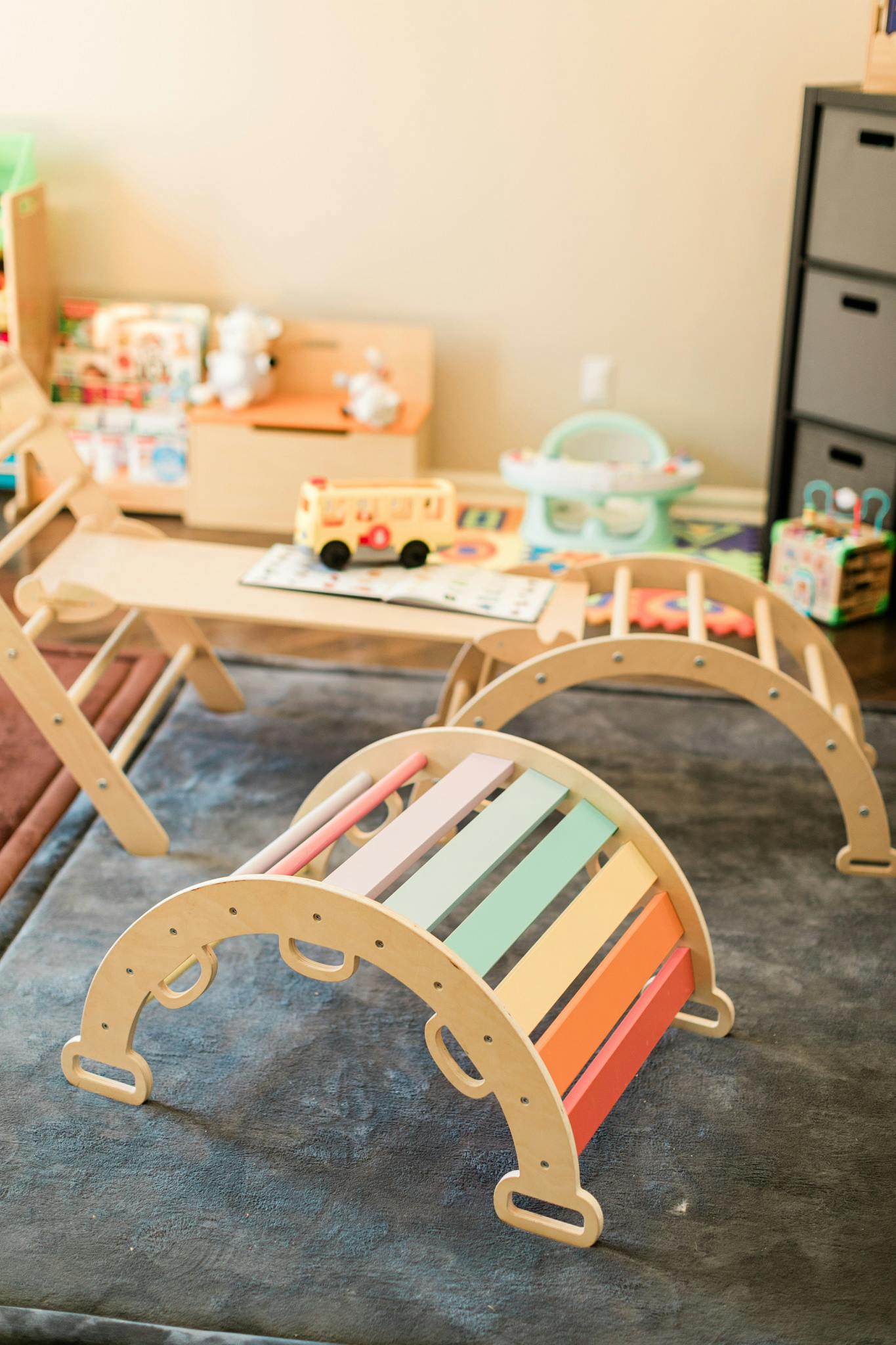 Two wooden climbing arches with colorful rungs in a playroom