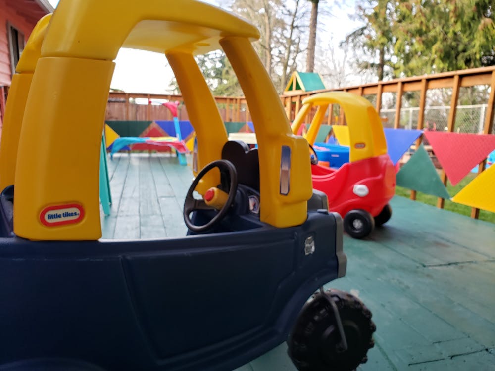 Two toy cars on a patio with colorful flags