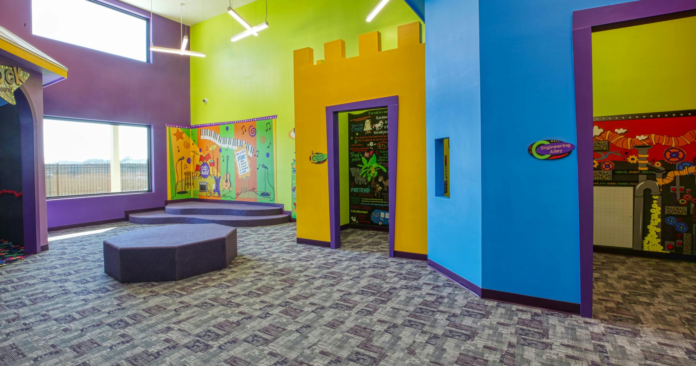 Colorful playroom with a stage and several activity areas