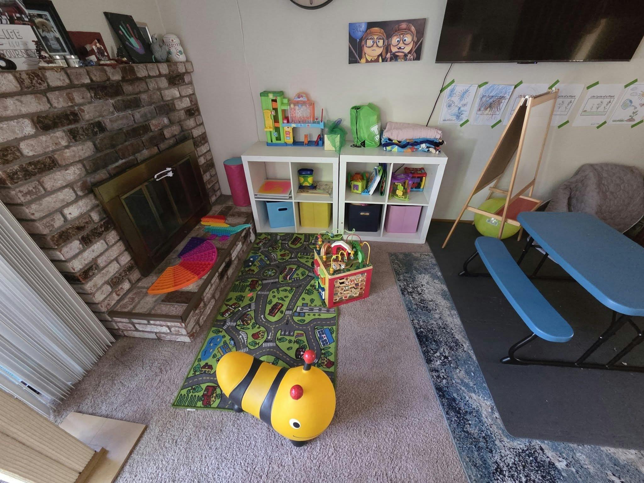 Playroom with children toys and furniture including a rug with a road pattern